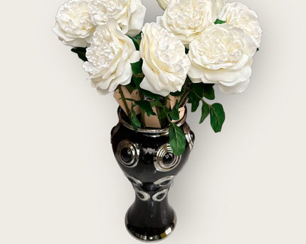 Een prachtige zwarte vaas met 10 grote, witte bloemen.
