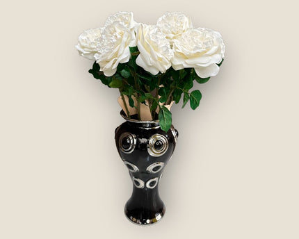 Een prachtige zwarte vaas met 10 grote, witte bloemen.